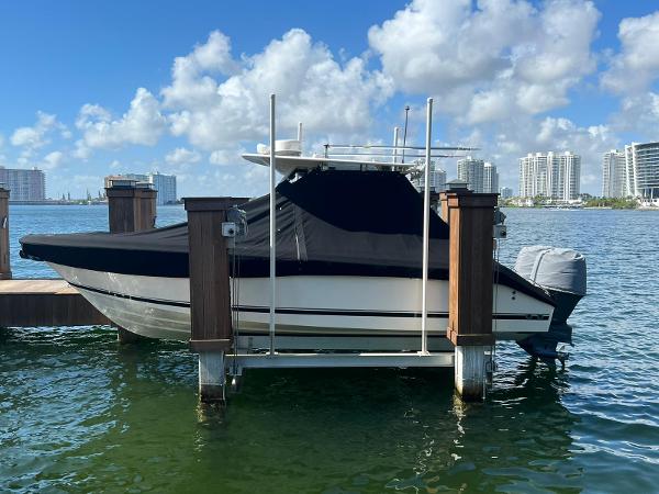 Pursuit C 260 Center Console 2013 Pursuit C 260 Center Console boat docked with cover, cityscape in background.