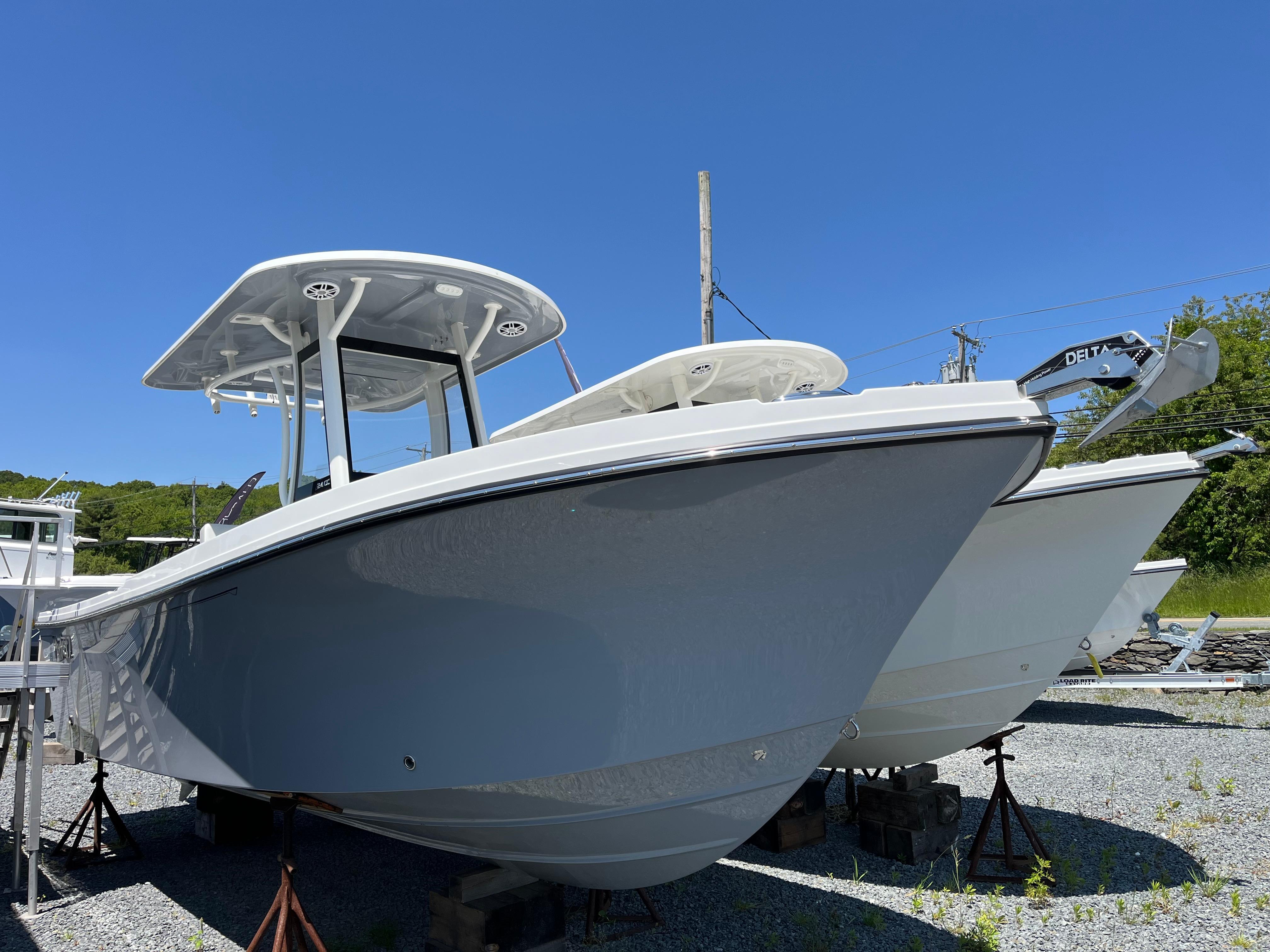 Parker 2400 Center Console 2024 Parker 2400 Center Console boat displayed outdoors on stands under clear blue sky.