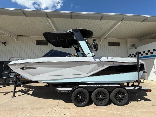 Nautique Super Air G23 2023 Nautique Super Air G23 boat on trailer, parked outside a building.