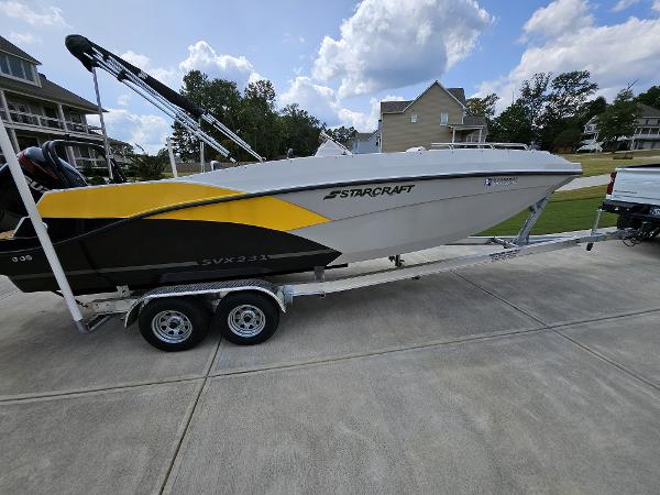 Starcraft SVX231 2022 Starcraft SVX231 boat on trailer, parked in residential driveway under blue sky.