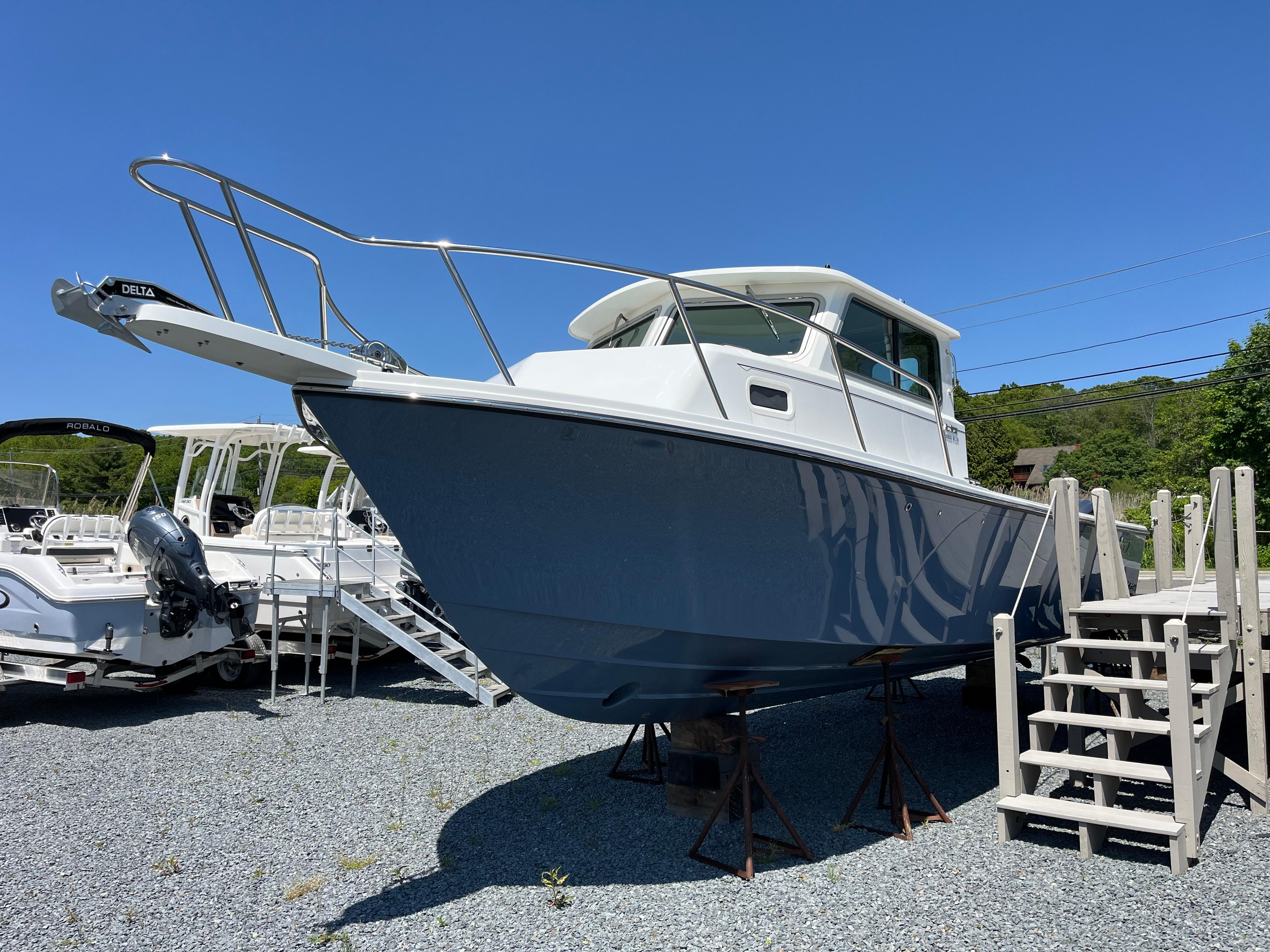 Parker 2820 XLD Sport Cabin 2024 Parker 2820 XLD Sport Cabin boat displayed on gravel lot under clear blue sky.