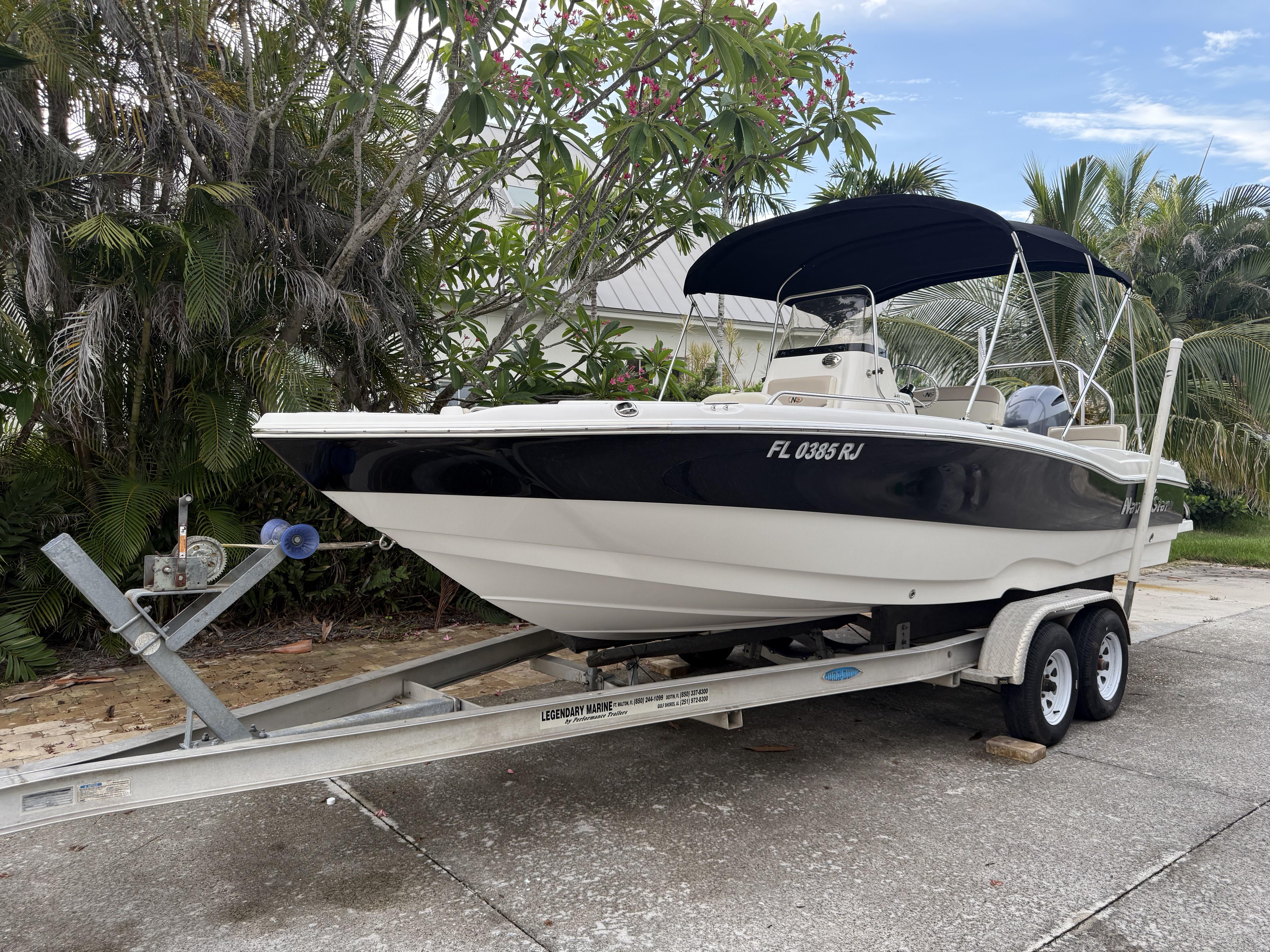NauticStar 211 Angler 2017 NauticStar 211 Angler boat on trailer, surrounded by lush greenery.