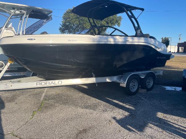 Bayliner DX2000 2024 Bayliner DX2000 boat on a Robalo trailer in a parking lot.