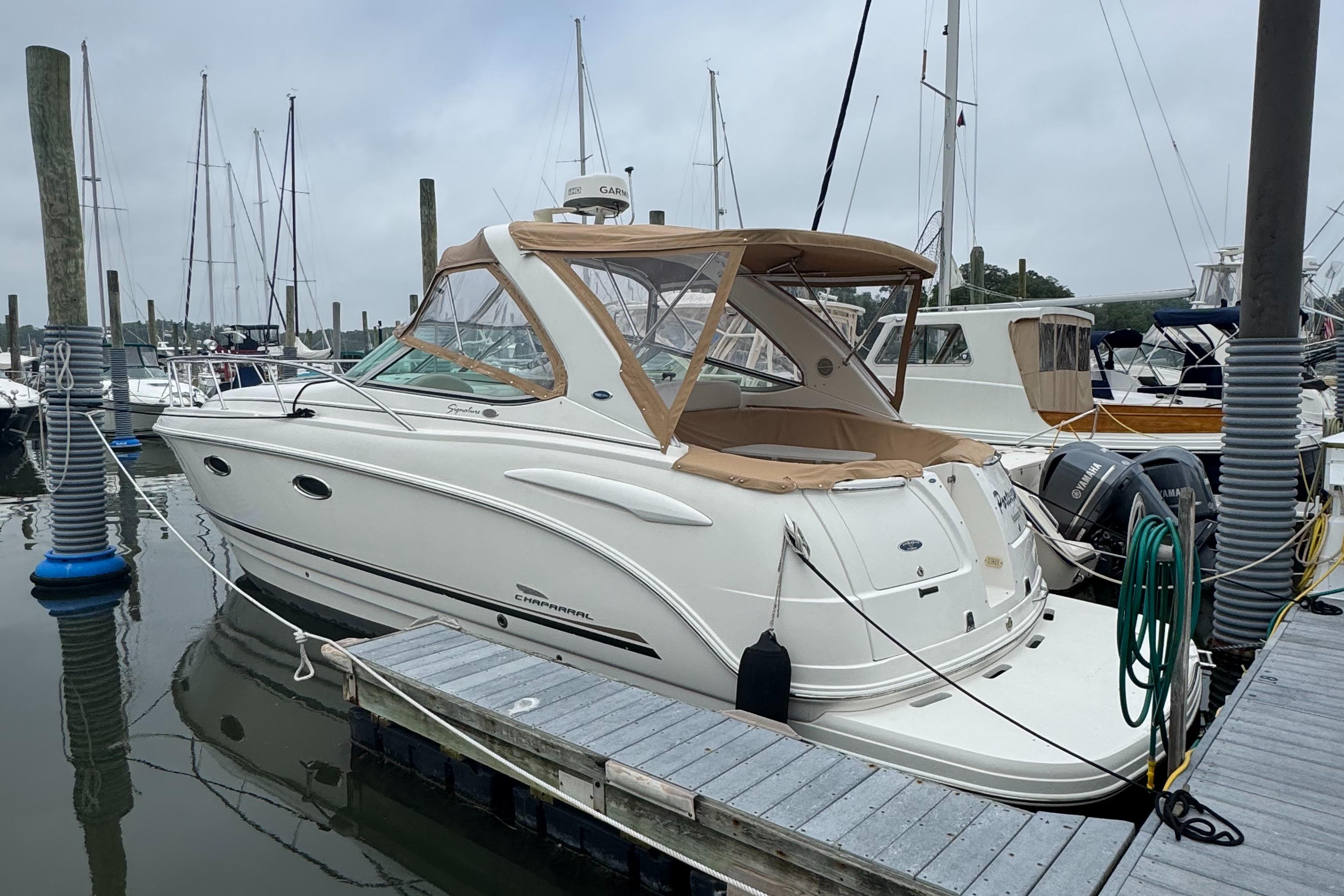 Chaparral 330 Signature 2004 Chaparral 330 Signature boat docked at marina, featuring sleek design and beige canopy.