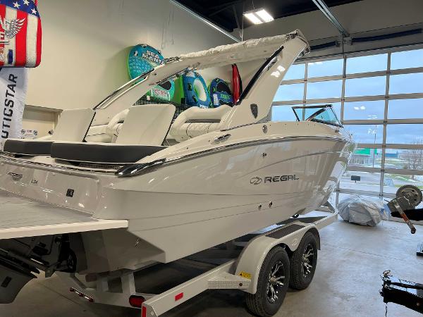 Regal LS4 2025 Regal LS4 boat on trailer in showroom, sleek white design.