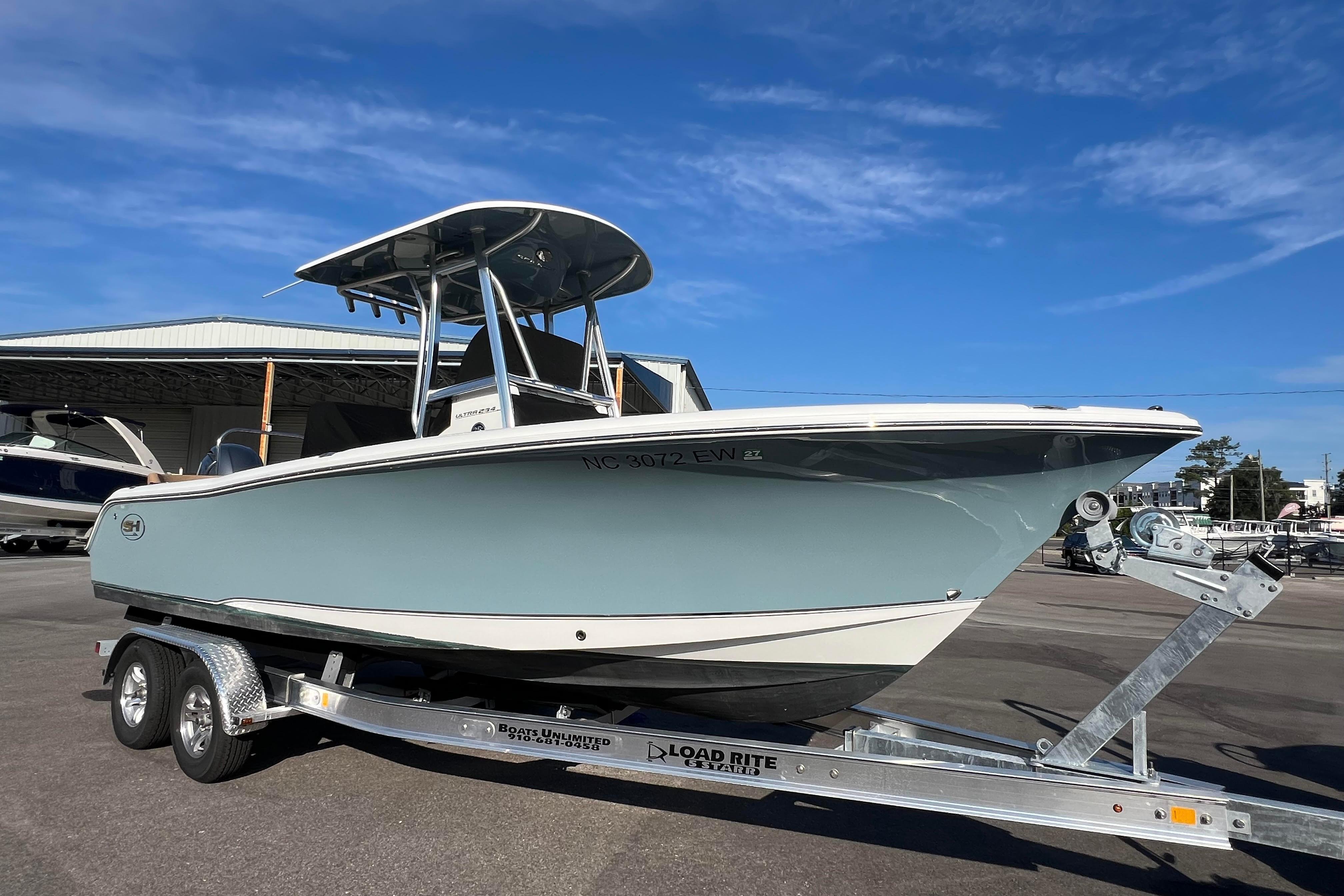 Sea Hunt Ultra 234 2021 Sea Hunt Ultra 234 boat on trailer under clear blue sky.