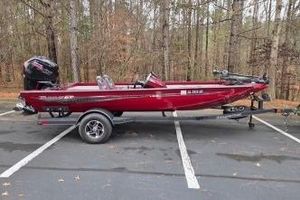 Ranger RT188C 2023 Ranger RT188C boat in red, parked in a wooded area.