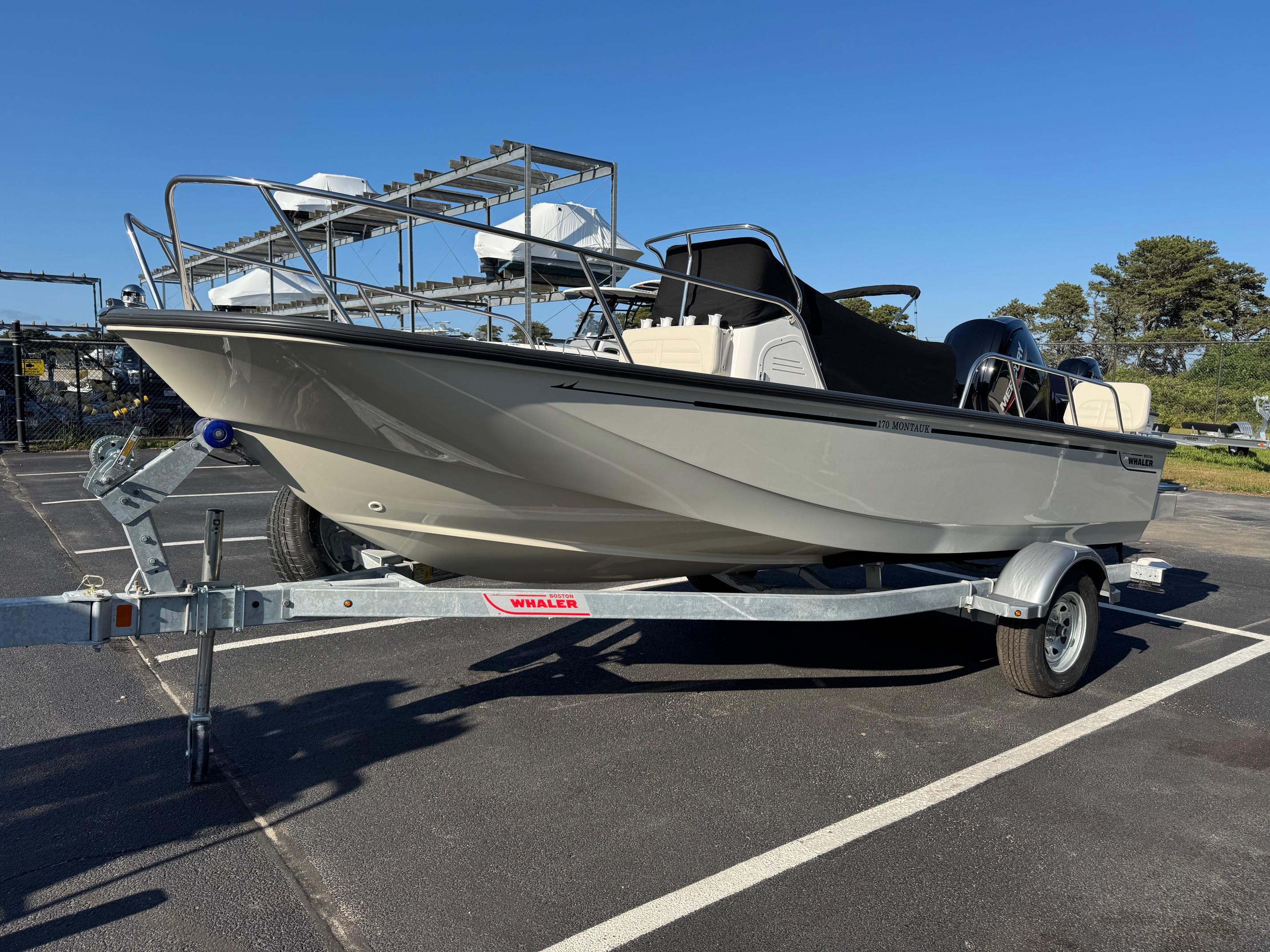 Boston Whaler 170 Montauk 2025 Boston Whaler 170 Montauk boat on trailer in parking lot, clear sky background.