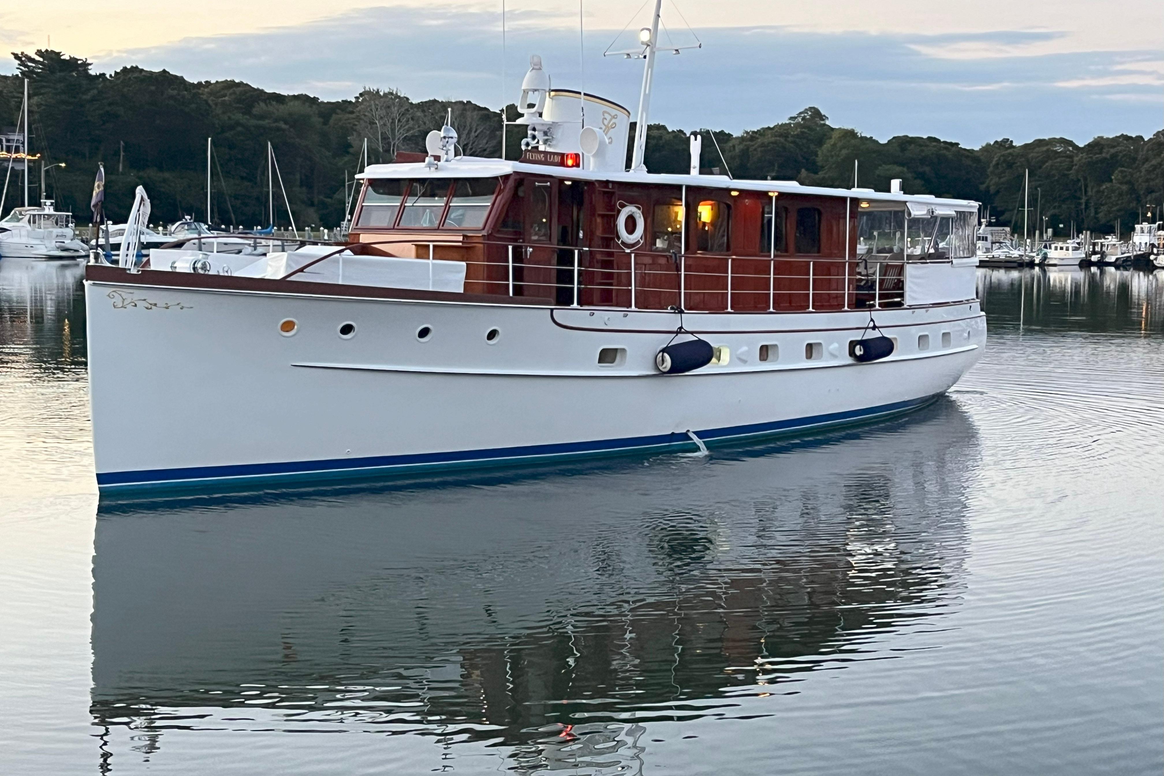Trumpy 58 Vintage 1937 Trumpy 58 yacht docked in serene marina setting.