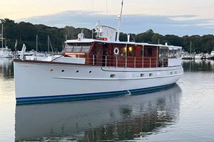 Trumpy 58 Classic 1937 Trumpy 58 yacht on calm water, surrounded by a serene marina setting.