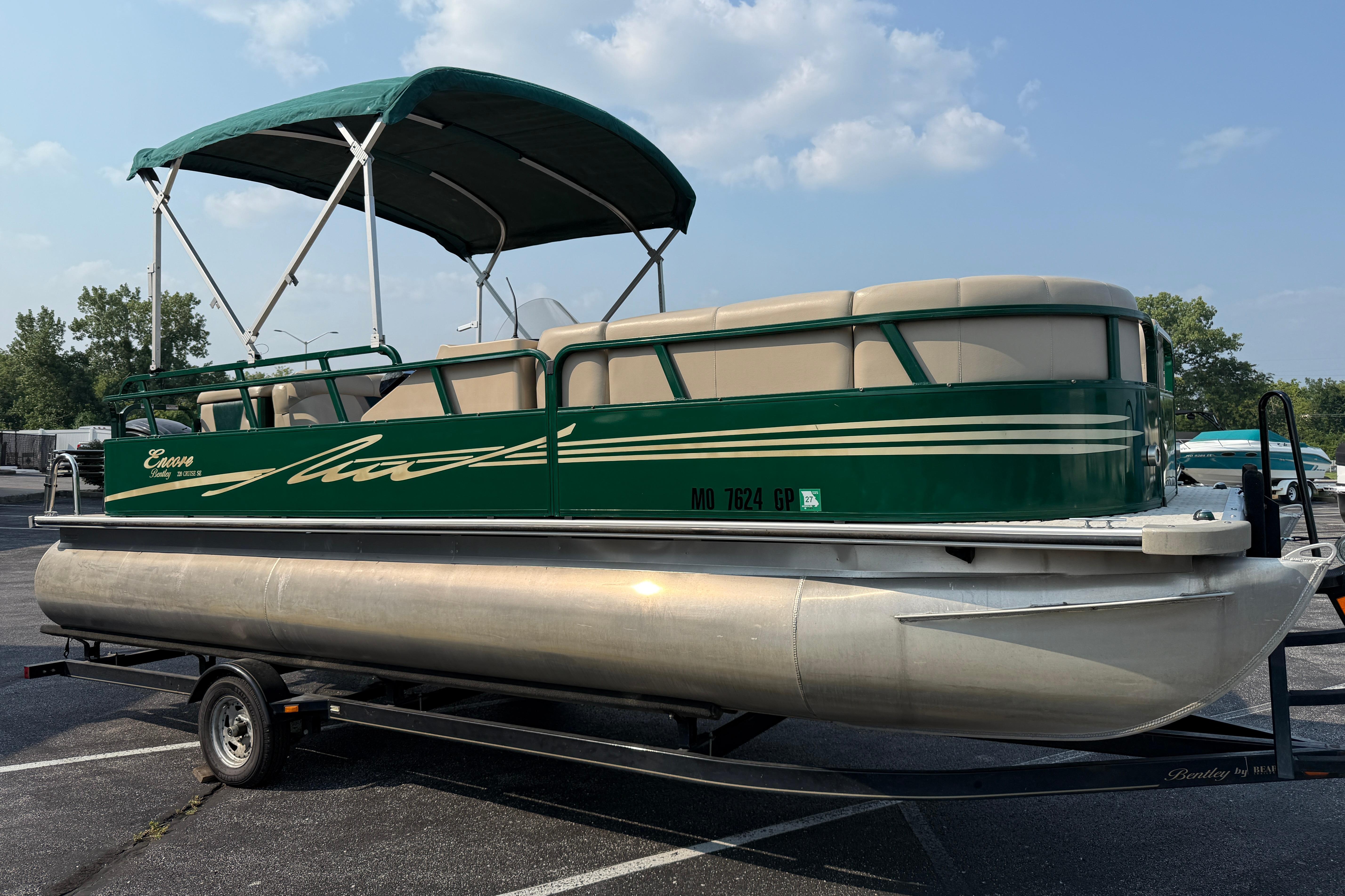 Bentley Pontoons 220 Cruise 2012 Bentley Pontoons 220 Cruise in green, parked on a trailer under a clear sky.