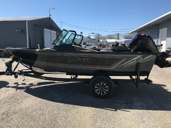 Lund 1775 Impact XS Sport 2025 Lund 1775 Impact XS Sport boat parked outdoors on a sunny day.