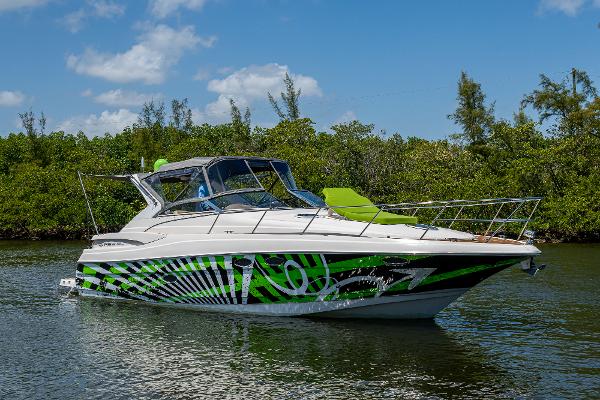 Regal Commodore 3560 IO 2006 Regal Commodore 3560 IO boat with vibrant green graphics on a calm waterway.