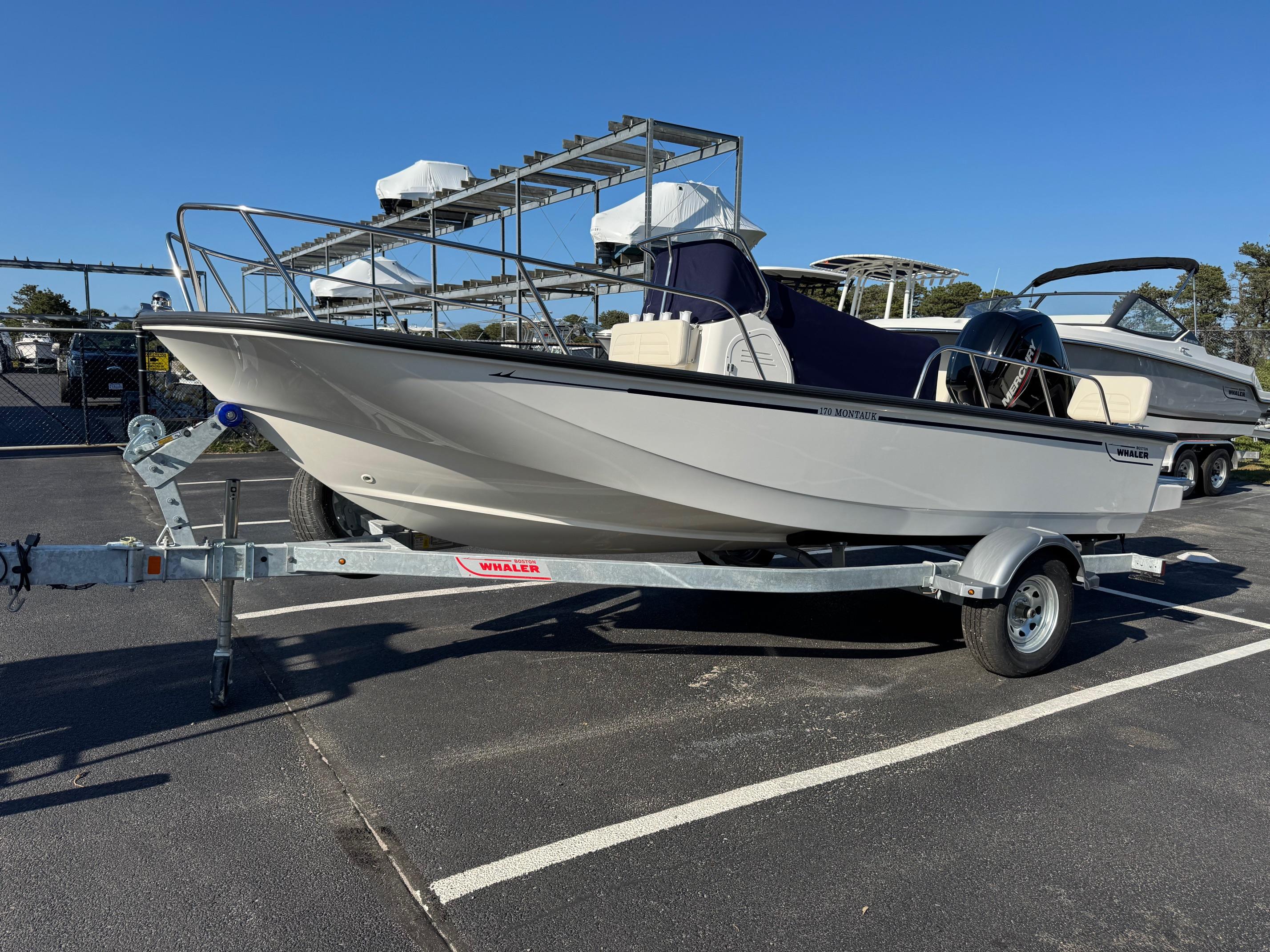 Boston Whaler 170 Montauk 2025 Boston Whaler 170 Montauk boat on trailer in parking lot.