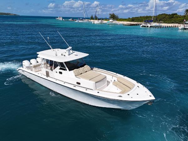 Pursuit S 408 Sport 2018 Pursuit S 408 Sport boat cruising in clear blue waters near a tropical island.