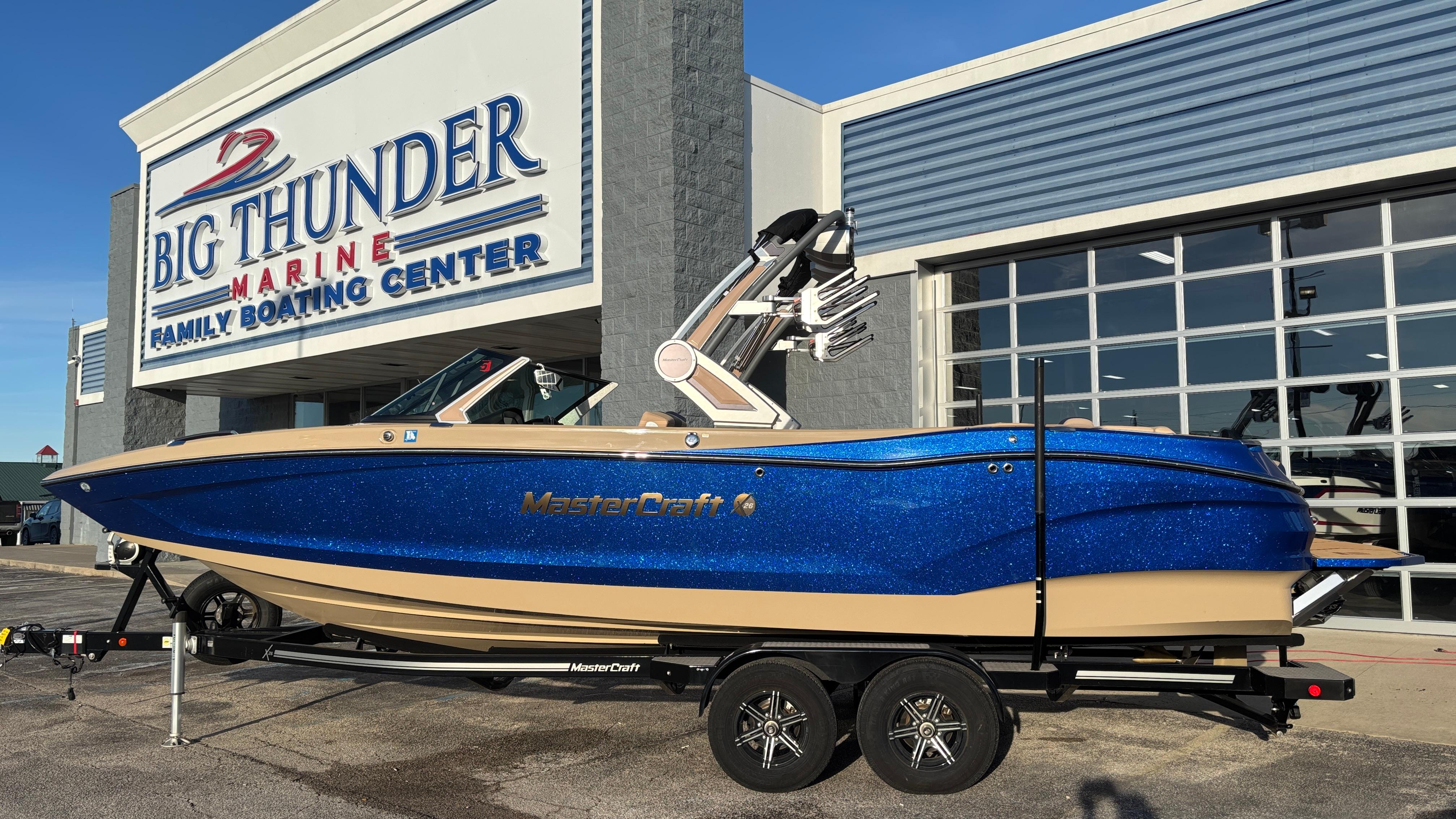 MasterCraft X26 2022 MasterCraft X26 boat in blue, displayed at Big Thunder Marine dealership.