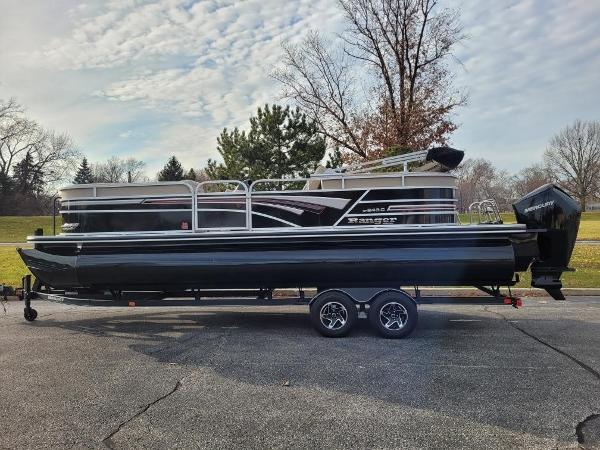 Ranger Reata 243C 2023 Ranger Reata 243C pontoon boat on a trailer in a park setting.