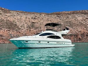 Azimut 42 Azimut 42 yacht from 2001 on turquoise water with rocky background.