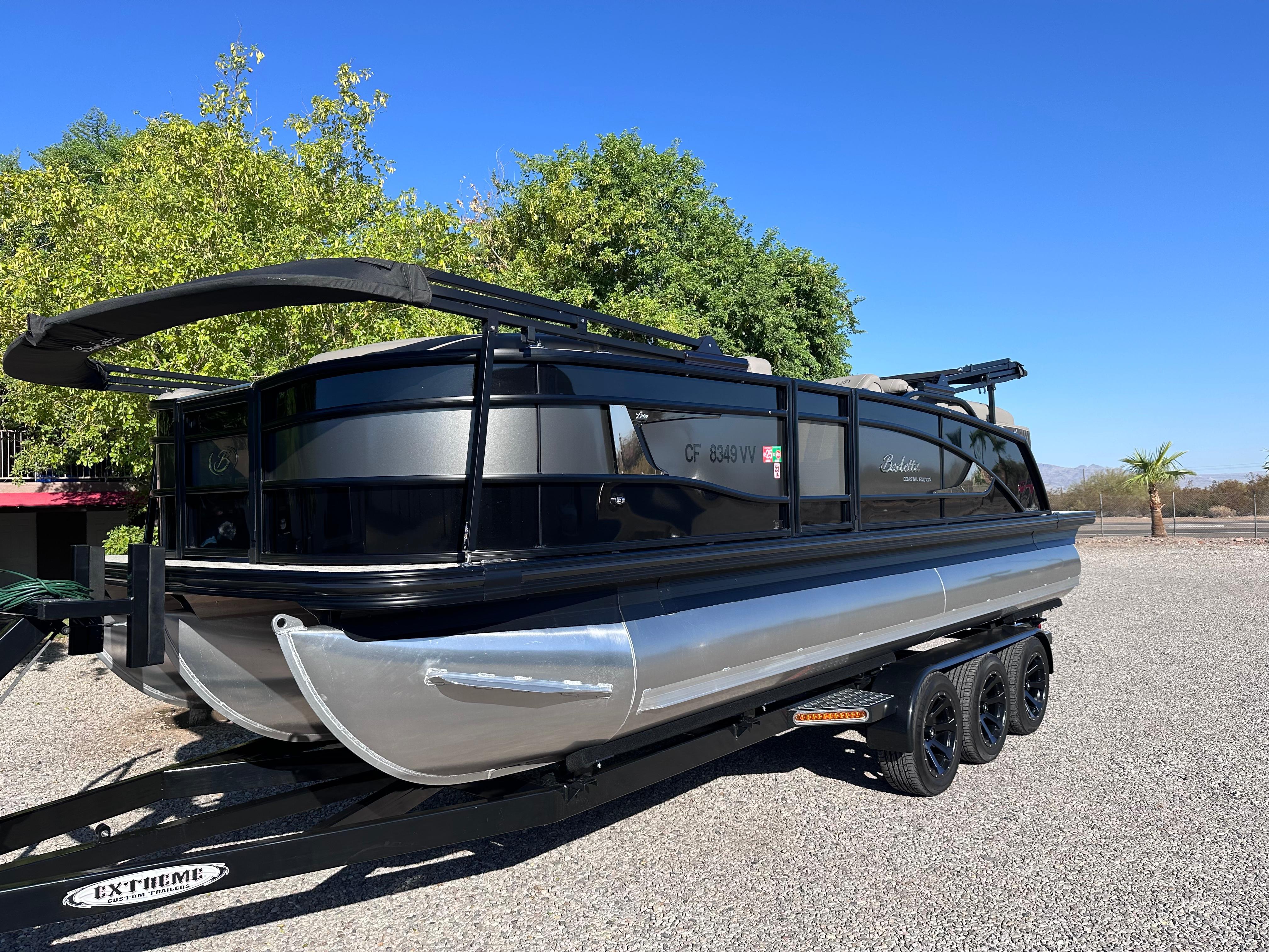 Barletta Lusso 23QCSS 2022 Barletta Lusso 23QCSS pontoon boat on trailer, parked outdoors.