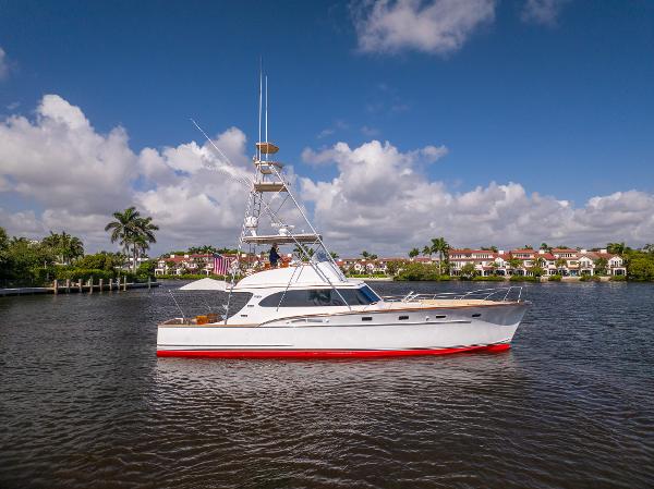 Rybovich 54 1970 Rybovich 54 yacht on calm water, clear sky, luxury waterfront homes in background.