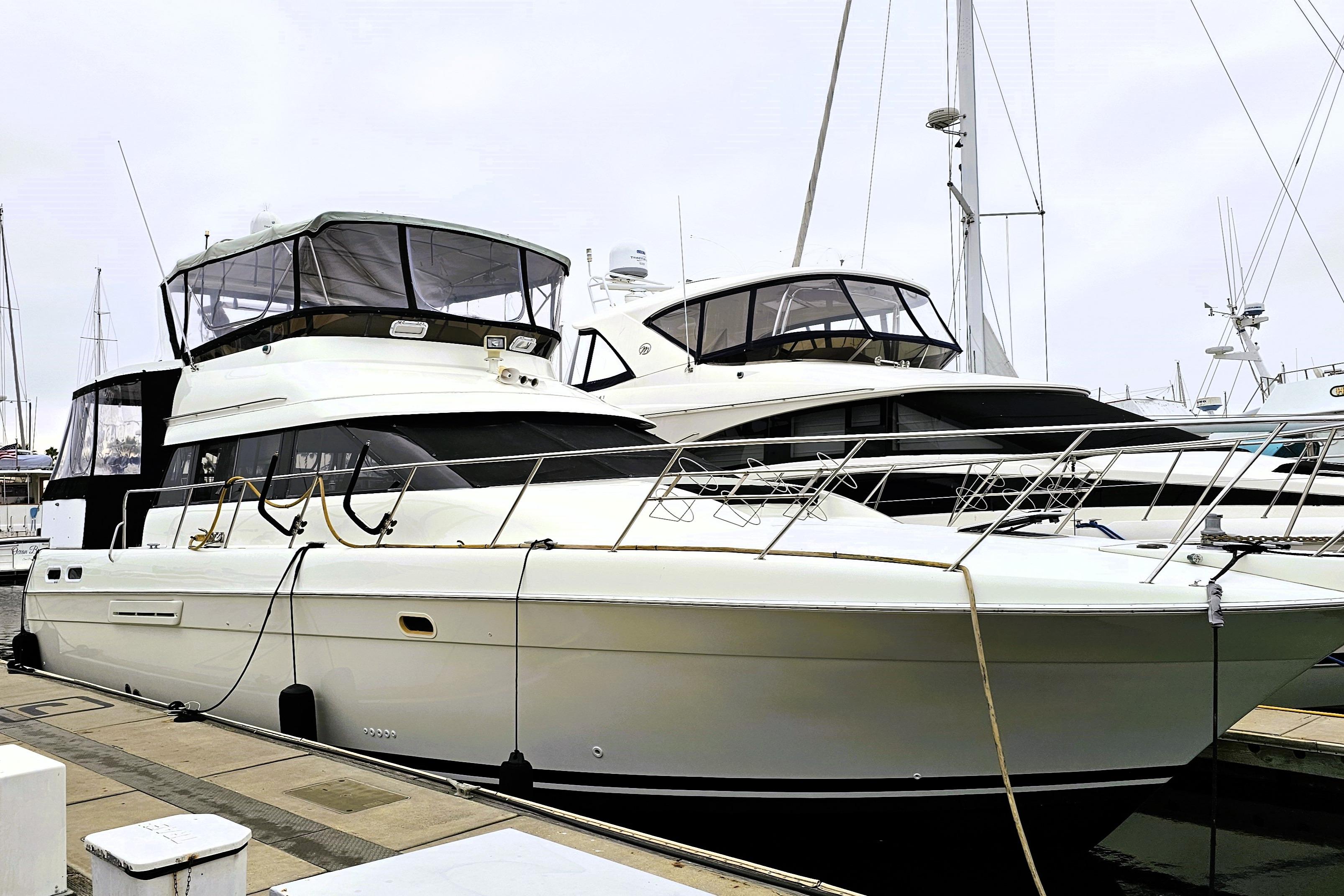 Silverton 46 1995 Silverton 46 yacht docked at marina, showcasing sleek design and spacious deck.