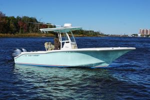 Key West 244 Center Console 2019 Key West 244 Center Console boat on a sunny day, cruising on a calm river.