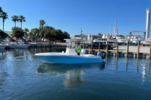 Caymas 24 HB 2026 Caymas 24 HB boat cruising in a marina with palm trees and docks.