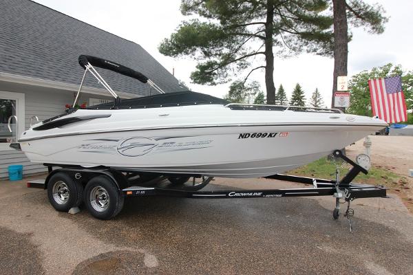 Crownline 21 SS 2015 Crownline 21 SS boat on a trailer, parked outdoors near a house.