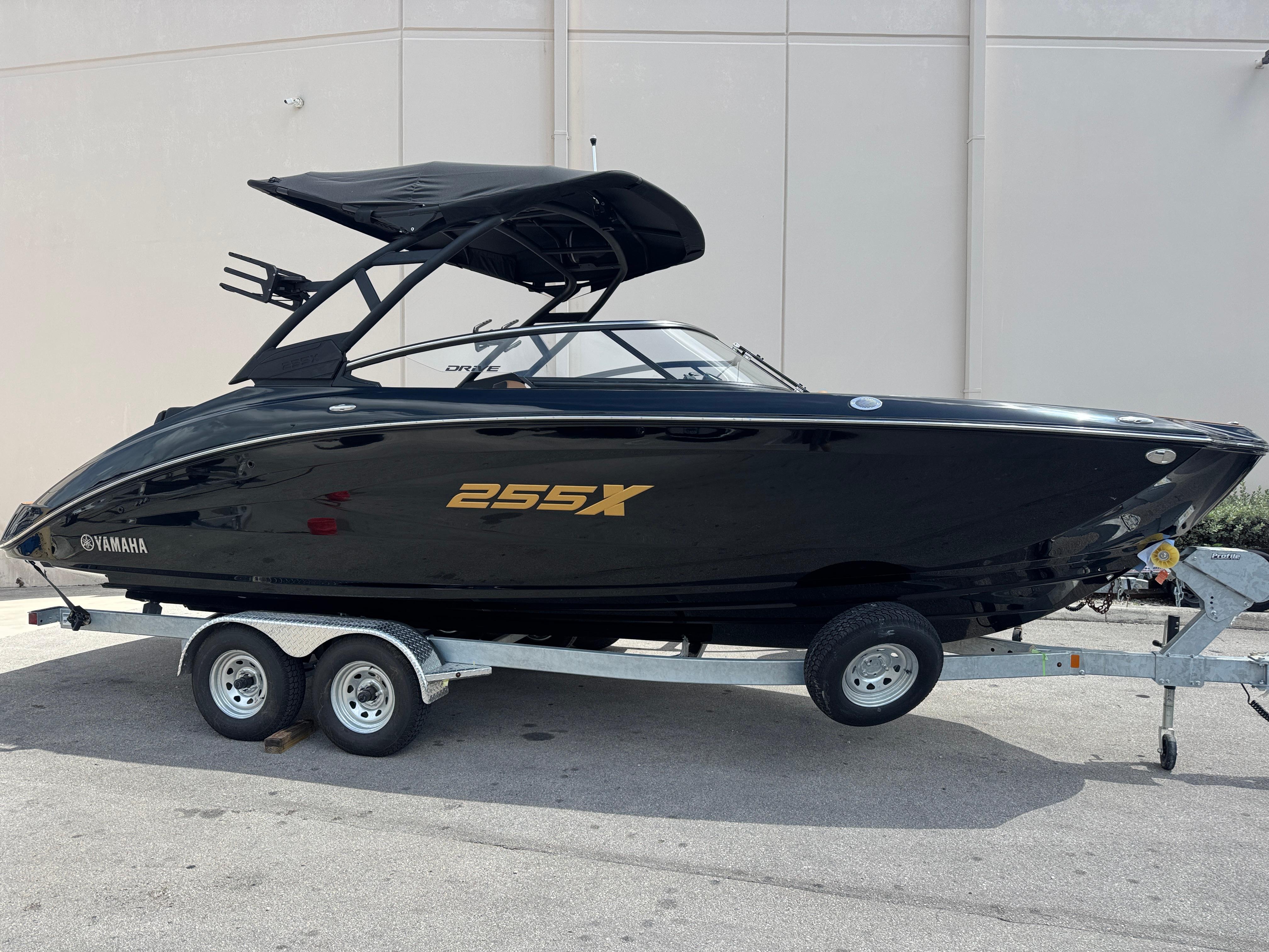 Yamaha Boats 255XD 2025 Yamaha Boats 255XD in black on trailer, sleek design, side view.