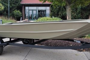 Tracker Grizzly 1754 Utility 2026 Tracker Grizzly 1754 Utility boat on trailer, parked outdoors near greenery.