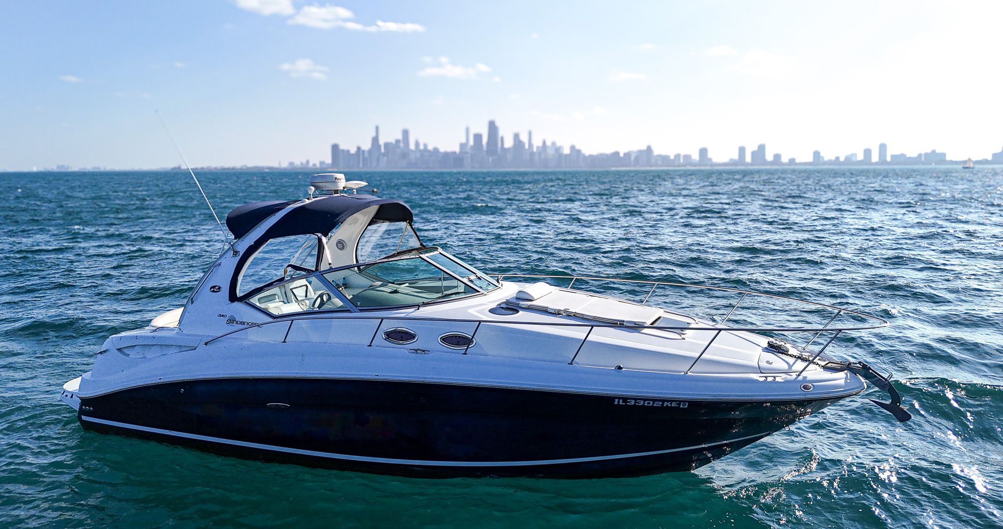 Sea Ray 320 Sundancer 2007 Sea Ray 320 Sundancer yacht on open water with city skyline in background.
