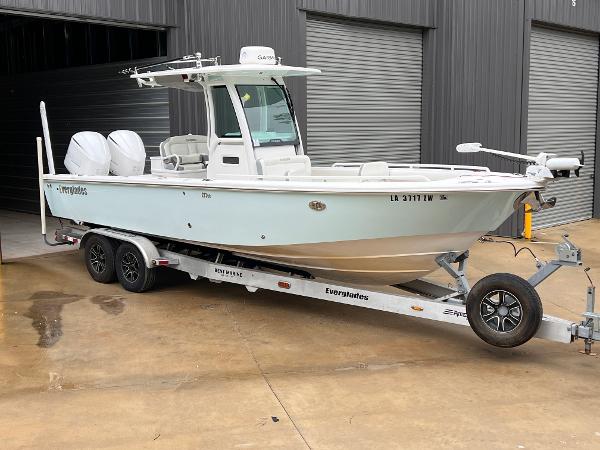 Everglades 273 CC 2018 Everglades 273CC boat on trailer, parked outside a warehouse.