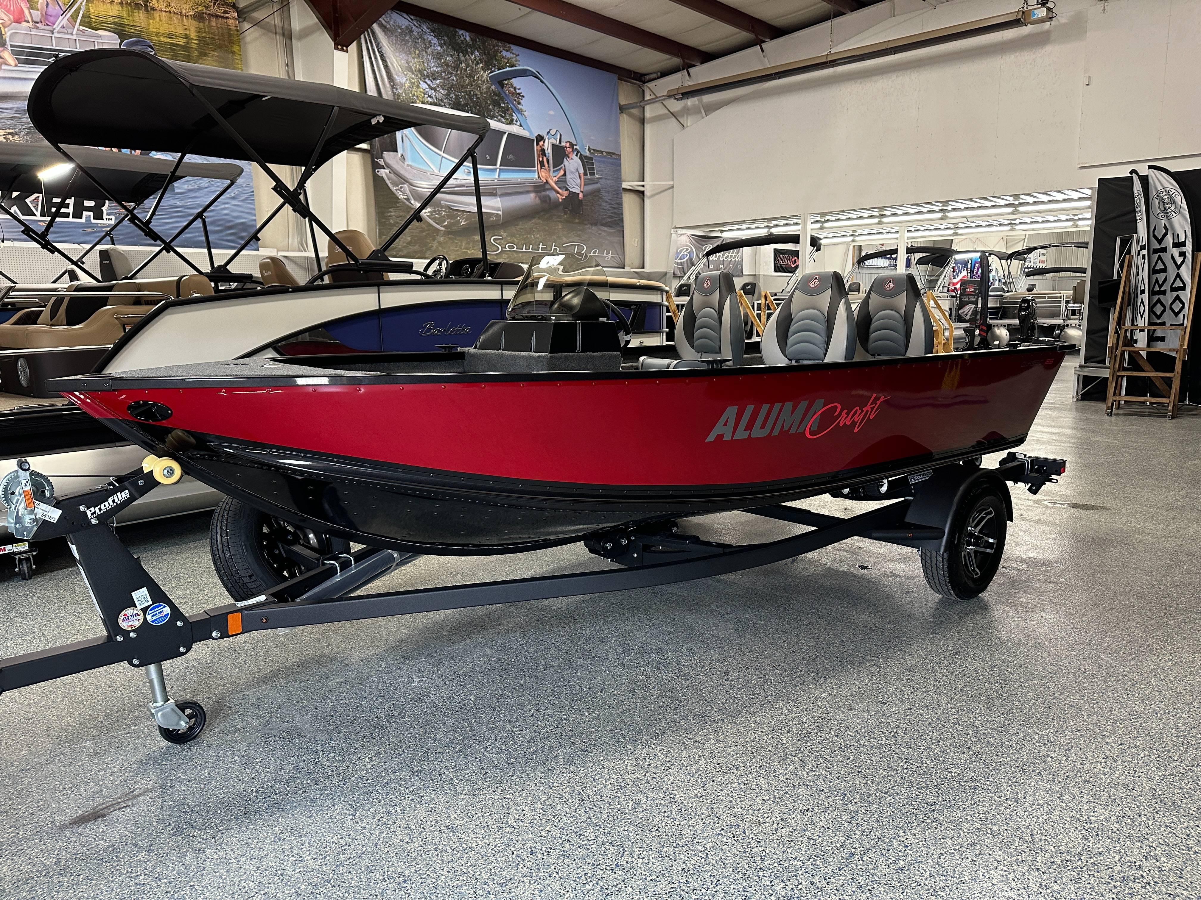 Alumacraft Classic 165 SC 2024 Alumacraft Classic 165 SC boat in showroom, red and black design, on trailer.