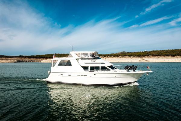Hatteras 52 Sport Deck Motor Yacht 1998 Hatteras 52 Sport Deck Motor Yacht cruising on open water under clear skies.
