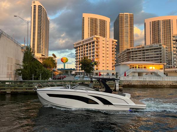 Hanover 377 Modern Hanover 377 boat cruising near urban high-rise buildings at sunset, 2023 model.