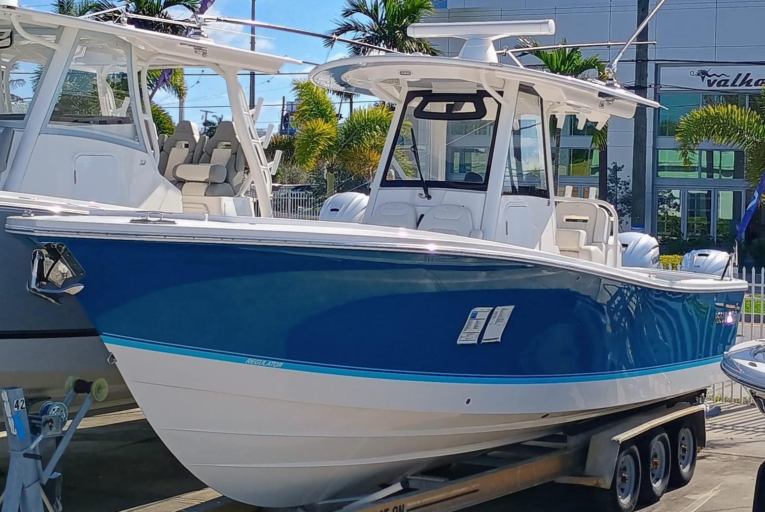 Regulator 31 2024 Regulator 31 boat with blue hull on trailer, displayed outdoors.
