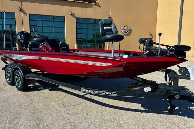 Ranger RT198P 2025 Ranger RT198P boat in red, parked on a trailer outside a building.