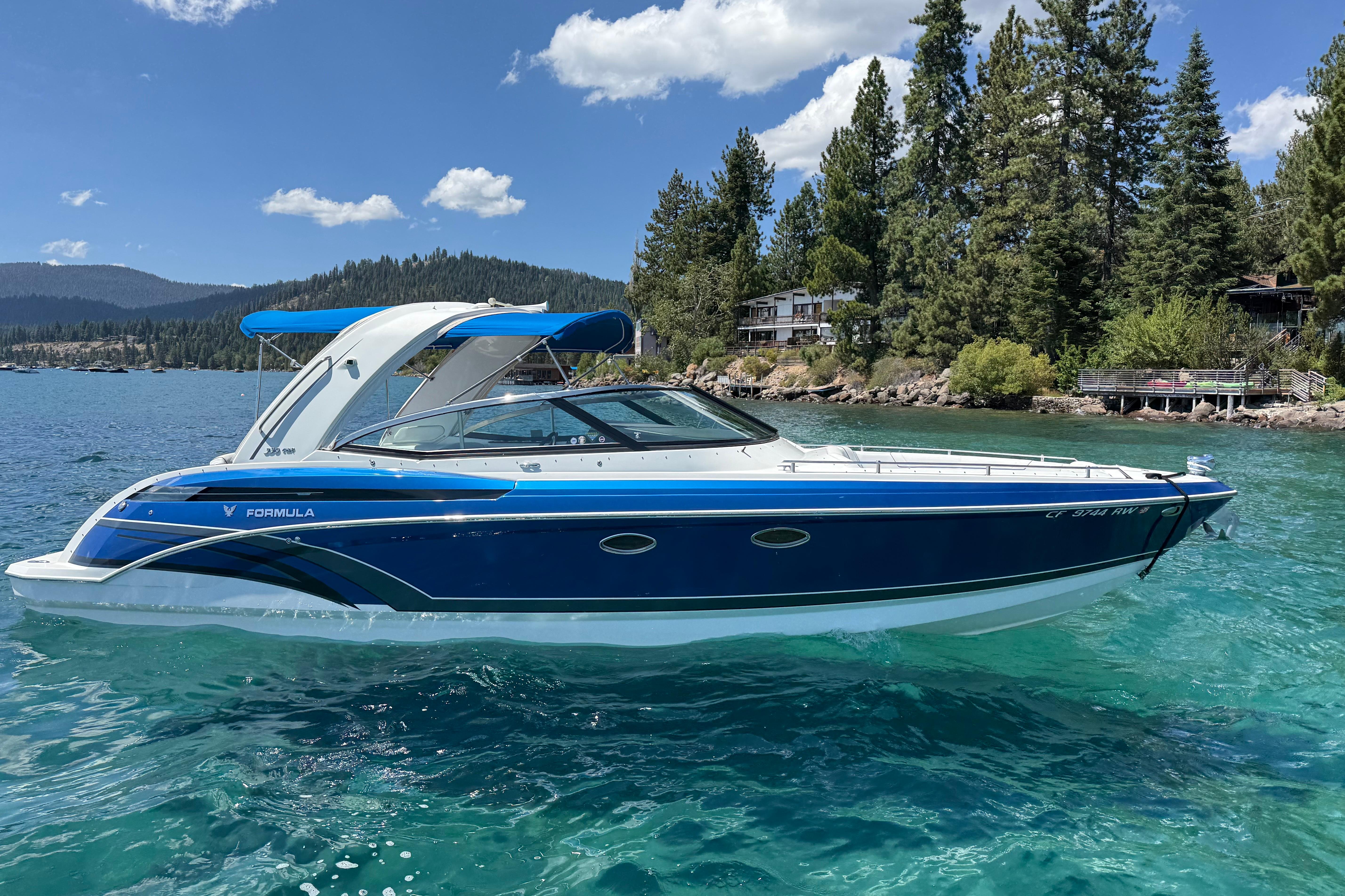 Formula 330 Crossover Bowrider 2018 Formula 330 Crossover Bowrider on a scenic lake with forested shoreline.