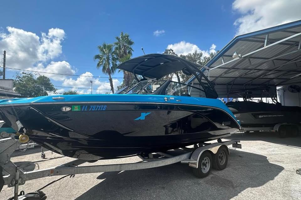 Yamaha Boats 222XD 2023 Yamaha Boats 222XD on trailer, blue and black design, parked outdoors under clear sky.