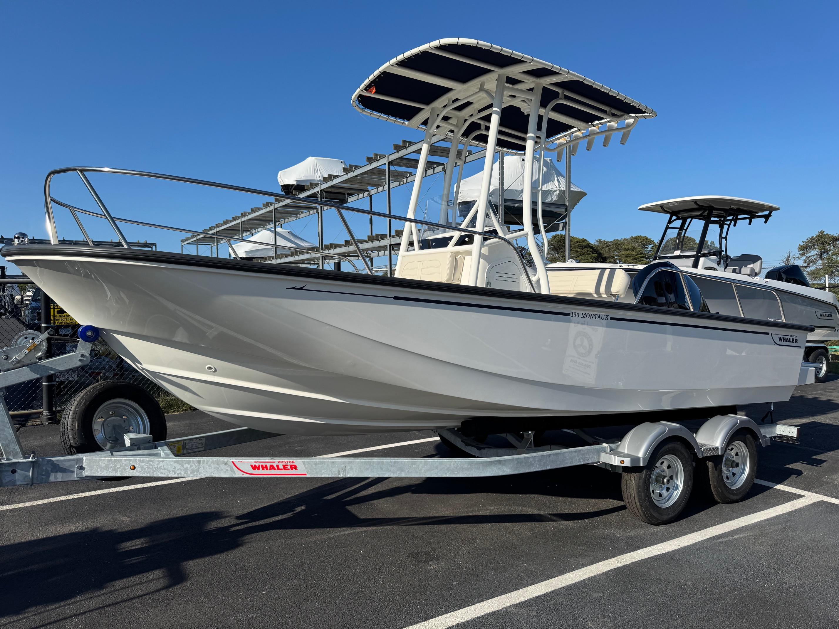 Boston Whaler 190 Montauk 2025 Boston Whaler 190 Montauk boat on trailer, displayed outdoors under clear blue sky.