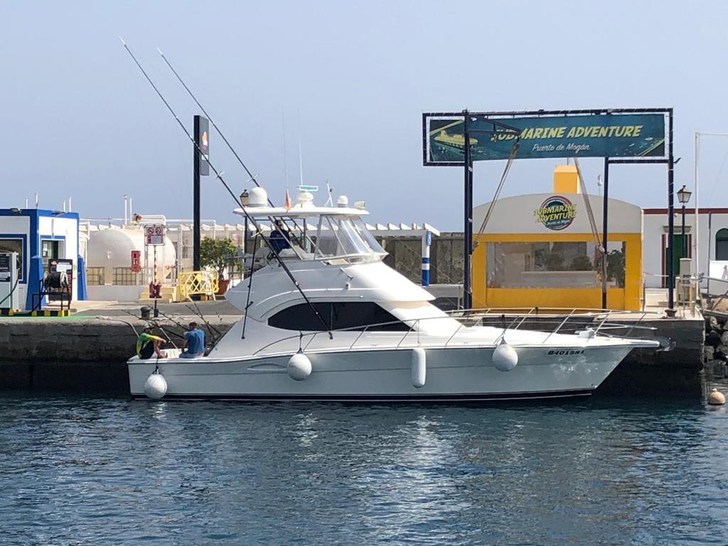 Riviera 40 Flybridge 2001 Riviera 40 Flybridge yacht docked near Submarine Adventure sign.