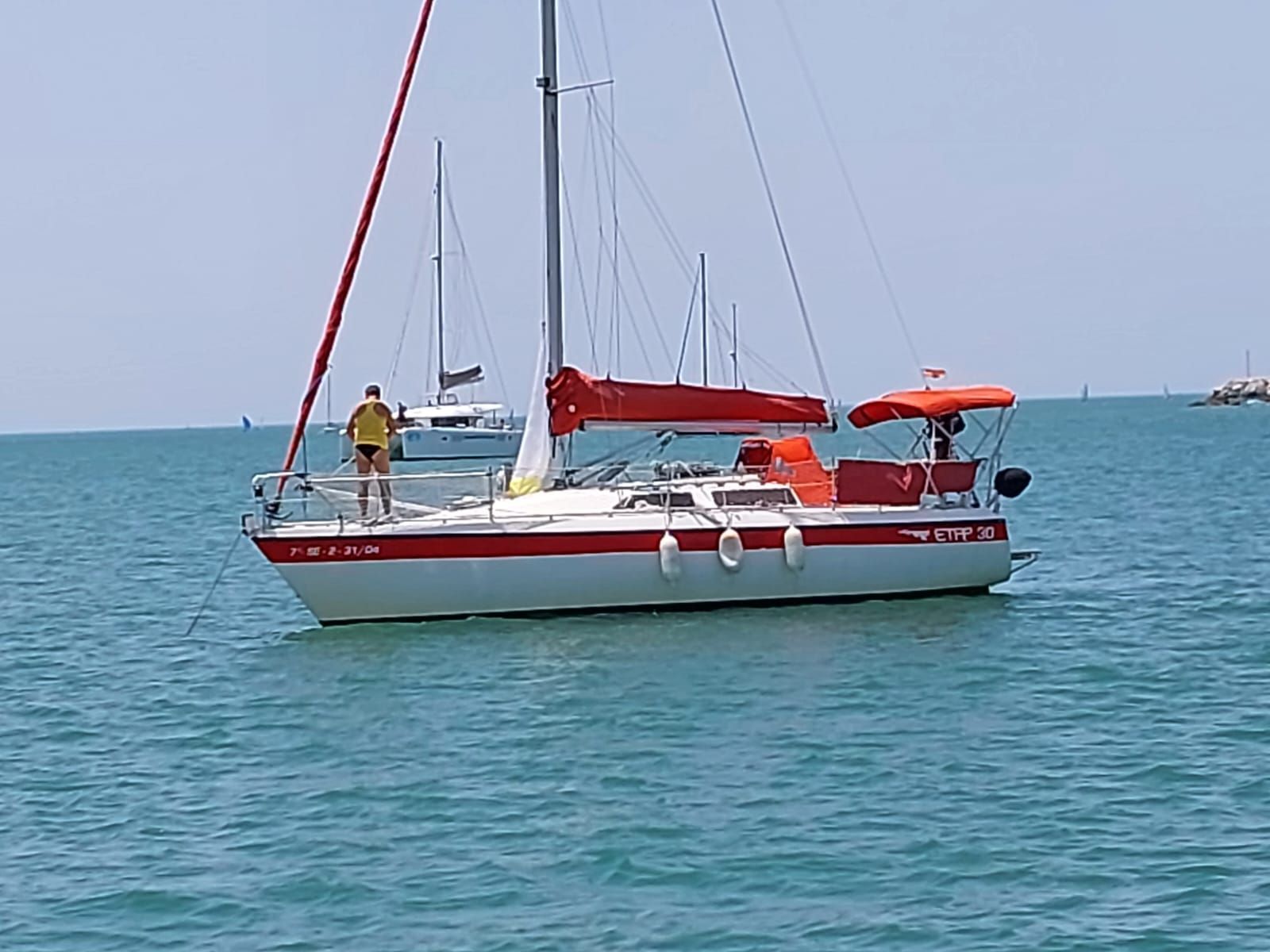 Etap 30 Sailboat Etap 30, 1991 model, with red accents, anchored in calm blue waters.