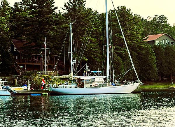 Sparkman & Stephens 65 Sailboat docked by a lakeside cabin, Sparkman & Stephens 65, 1966 model.