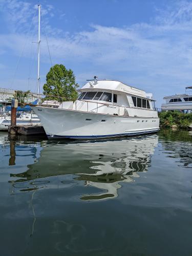 Chris-Craft Roamer 1976 Chris-Craft Roamer yacht docked on calm water under a clear blue sky.