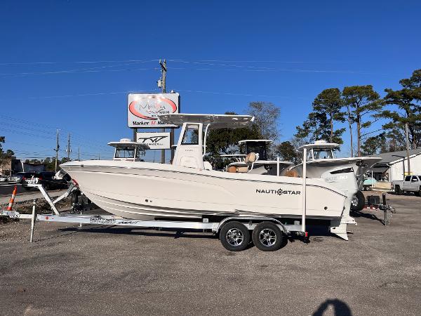 NauticStar 242L Offshore 2025 NauticStar 242L Offshore boat on trailer, parked outdoors under clear blue sky.