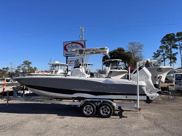 NauticStar 231 Hybrid 2025 NauticStar 231 Hybrid boat on trailer, parked outdoors under clear blue sky.
