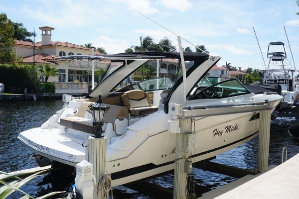 Cruisers Yachts 328 BR 2015 Cruisers Yachts 328 BR docked by waterfront homes, sunny day, luxury boat.