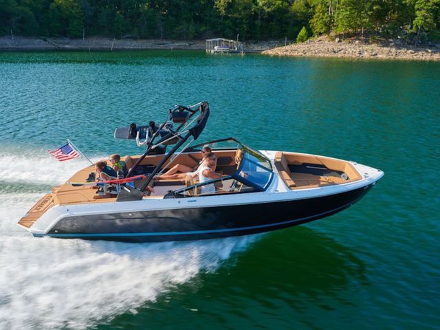 Cobalt CS23 2025 Cobalt CS23 boat cruising on a lake with passengers, American flag waving.
