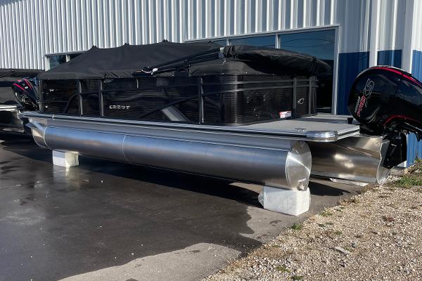 Crest CLASSIC 220 L 2025 Crest CLASSIC 220 L pontoon boat with cover, parked outside a building.