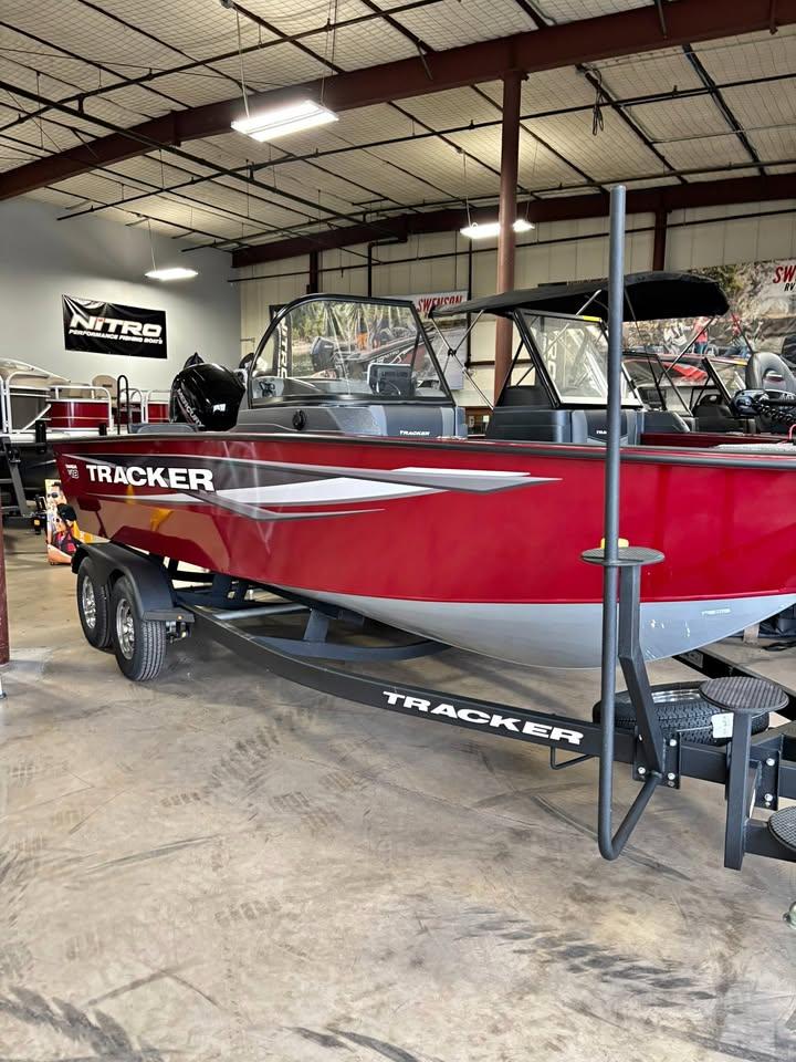 Tracker Targa V-18 Combo 2025 Tracker Targa V-18 Combo boat in showroom, red exterior, on trailer.
